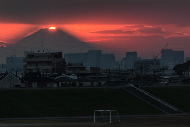 山頂に沈む夕陽と富士山